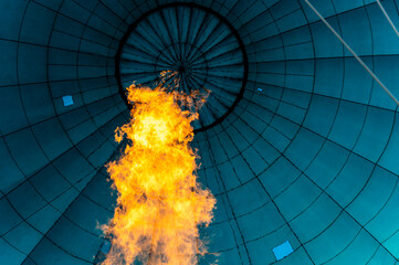 Vibrant powerful flame filling blue bulb textile of balloon with hot air