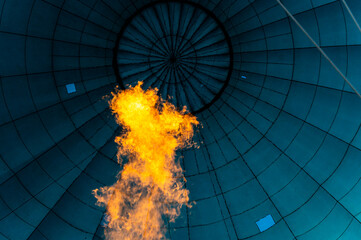 Vibrant powerful flame filling blue bulb textile of balloon with hot air