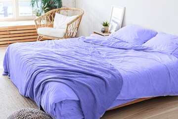 Loft bedroom interior, bed linen colored in trendy color of year 2022 Very Peri background....