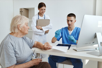 Obraz premium elderly woman in hospital with doctor and nurse health care