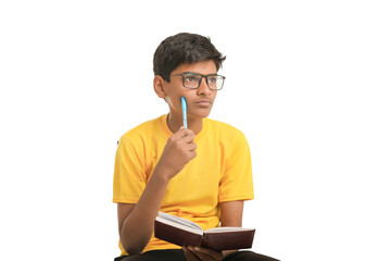 Indian boy holding diary in hand and thinking some idea on white background.