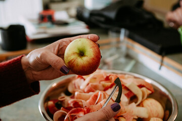Hands pealing apples on the kitchen counter