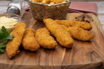 aiguillettes de poulet panées frites avec sauce et pommes de terre rissolées