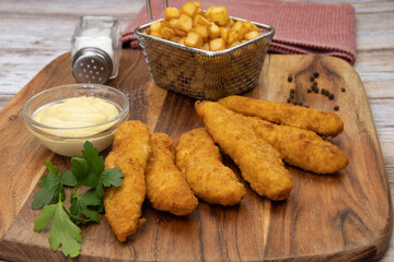 aiguillettes de poulet panées frites avec sauce et pommes de terre rissolées