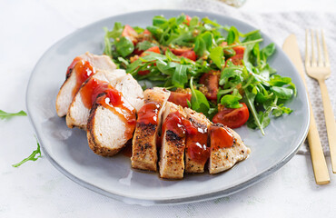 Roasted chicken fillet with salad  fresh tomatoes and arugula.