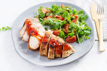Roasted chicken fillet with salad  fresh tomatoes and arugula.