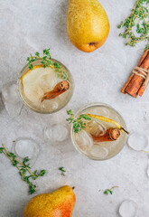 Festive summer spicy cocktail with pears and thyme on light beige background.
