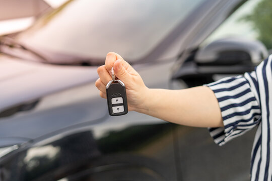An employee of a tourist car rental company presents the car keys with a test drive. Good service before agreeing to a lease or purchase contract.