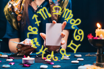 Divination and astrology. Witch holding an empty white tarot card. Zodiac circle. Copy space....