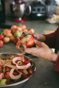 Hands pealing apples on the kitchen counter