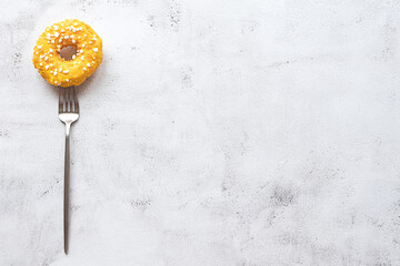 Donut on a fork, flat lay on grey background