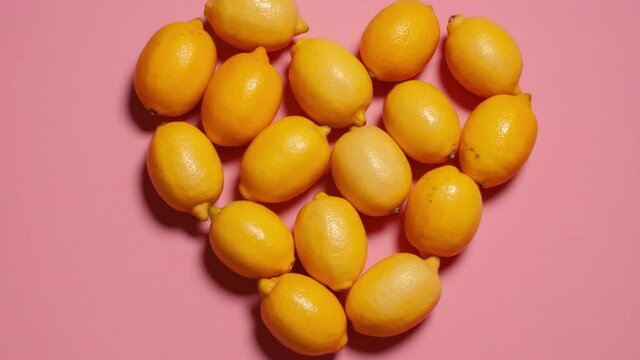 Movement of lemons on a pink background. Stop motion. The movement of lemons in the heart. Time lapsed
