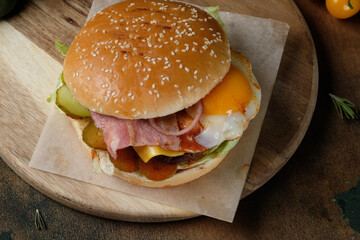 Juicy burger with egg on a wooden background