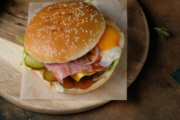 Juicy burger with egg on a wooden background
