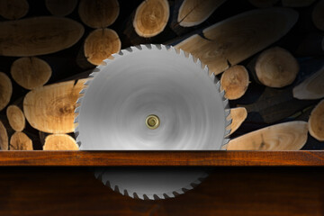 Close-up of a metal circular saw blade in motion in a wooden workbench with a group of sawn logs in...