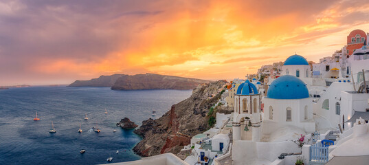 Amazing sunset panoramic landscape, luxury travel vacation. Oia town on Santorini island, Greece. Traditional famous houses and churches with blue domes over the Caldera Aegean sea. Destination scenic - obrazy, fototapety, plakaty
