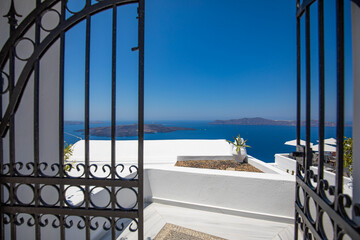 Entrance of a typical White cycladic architecture, house with blue door and blooming pink...