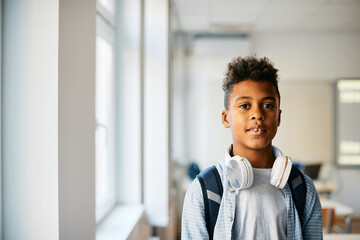 Portrait of black elementary student in classroom looks at camera.