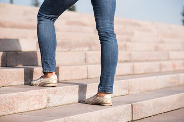 Close up of female legs climbing the steps up.