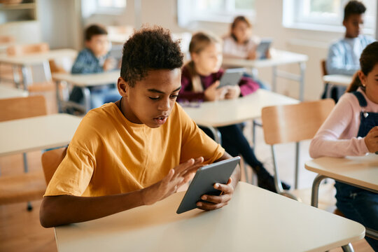 Black Schoolboy E-learning On Digital Tablet During Class In Classroom.