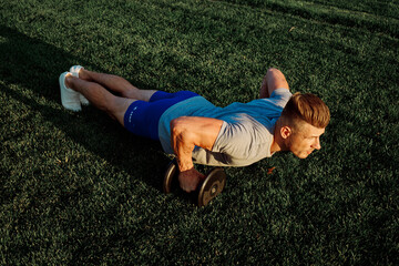 Fototapeta na wymiar athletic man in the park workout exercise dumbbells