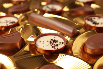 Chocolate candies in box all over background, close up