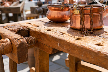 Vintage copper cauldrons on antique carpenter workbench - flea market in Italy