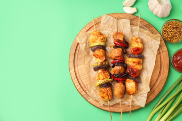 Concept of tasty food with chicken shashlik on green background