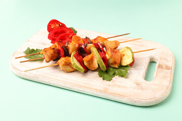 Concept of tasty food with chicken shashlik on mint background