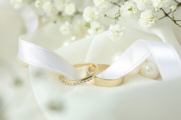 Concept of wedding accessories with wedding rings, close up