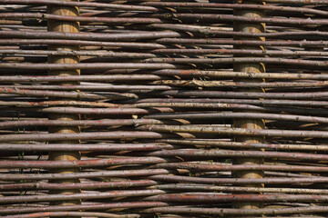 A close-up of a fence made out of branches of a Willow
