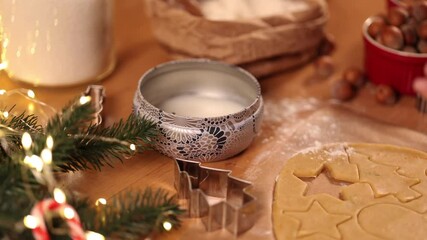 Woman lights a candle on Christmas. Preparing for baking gingerbread. Christmas mood