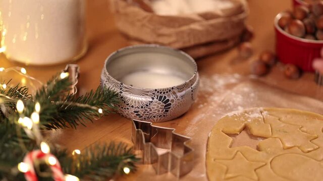 Woman lights a candle on Christmas. Preparing for baking gingerbread. Christmas mood