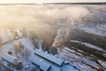 Aerial view of Venta river waterfall, the widest waterfall in Europe in foggy winter day, Kuldiga, Latvia
