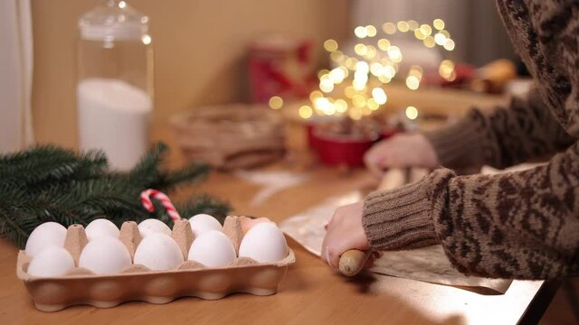 Woman using rolling pin for making gingerbread. Close-up of rolling raw dough for gingerbread. Christmas mood. Preparing for hollidays
