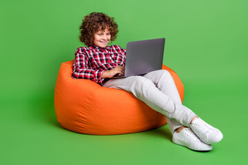 Portrait of handsome trendy cheerful guy using laptop see film movie video isolated over bright green color background