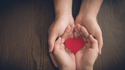 Couple in love holding a red heart in their hands