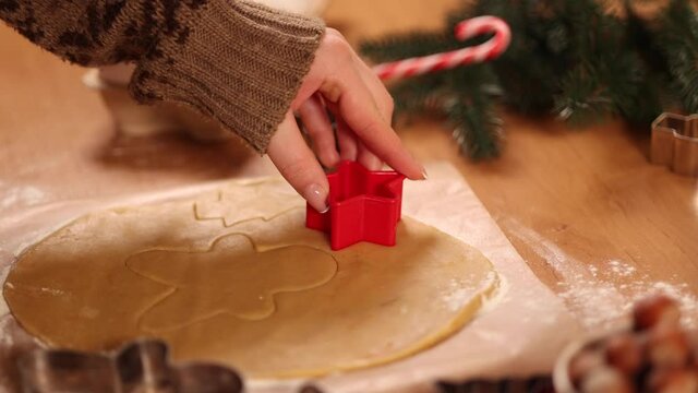 Woman making gingerbread at home. Female cutting cookies of gingerbread dough. Christmas and New Year traditions concept. Christmas bakery. Happy hollidays