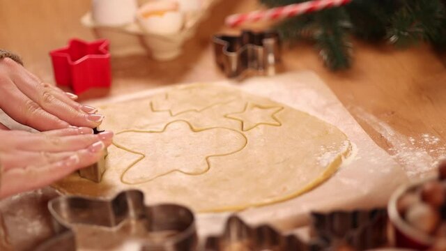 Woman making gingerbread at home. Female cutting cookies of gingerbread dough. Christmas and New Year traditions concept. Christmas bakery. Happy hollidays