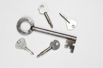 Door metal keys of different shapes on a light background, top view. Flat lay concept.