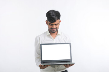 Young indian man showing laptop screen with copy space on white background.