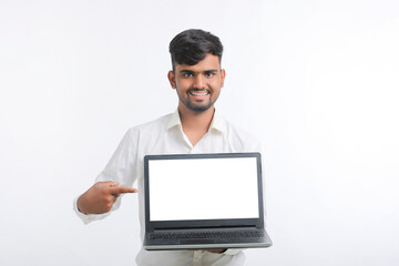 Young indian man showing laptop screen with copy space on white background.