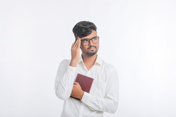 Young indian man holding diary in hand and thinking some idea.