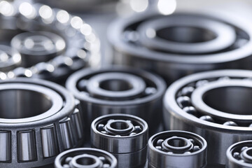 Set of deep groove ball and roller bearings on a gray background with soft focus. Axial chrome...