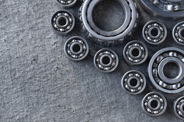 Set of deep groove ball and roller bearings on a gray background with space for text. Top flat top view of axial lubricated bearings for heavy machinery and mechanical engineering with copy space.