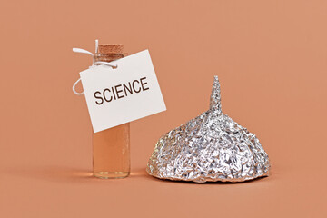 Concept for fighting conspiracy theories with science with tinfoil hat and cure bottle