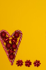 Christmass flatlay heart lined with Christmas lollipops and decorated with Christmas tree toys 