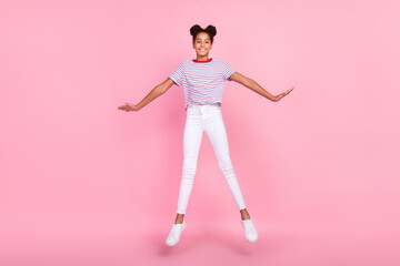 Fototapeta na wymiar Full body photo of brown bun haired stylish trendy african american girl wear casual outfit jump isolated on pink color background