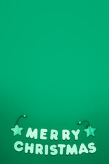 Text Merry Chritmas on green background, vertical format