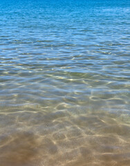 Calm sea water surface texture with splashes and waves. Abstract nature background. Background of aqua ocean water surface.